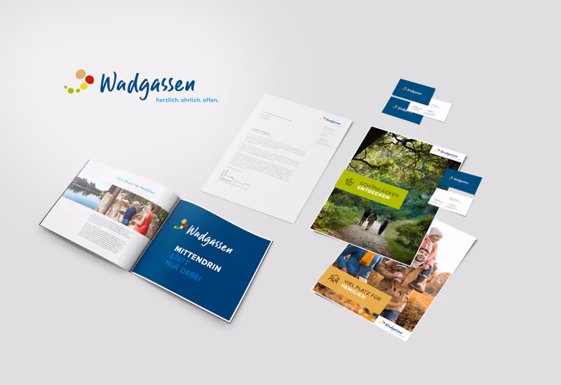 Das neue Erscheinungsbild der Gemeinde Wadgassen: Logo mit dem Claim „herzlich. ehrlich. offen.“, dazu Briefbogen, Visitenkarten, eine aufgeschlagene Broschüre und Flyer